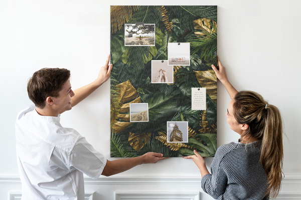 Memobord van kurk met gouden bladeren in een tropische plantencompositie