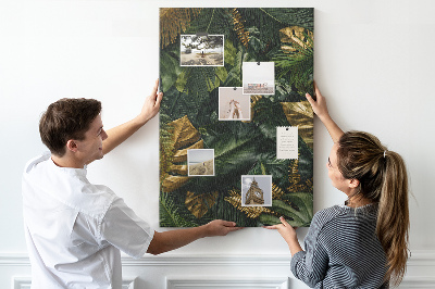 Memobord van kurk met gouden bladeren in een tropische plantencompositie