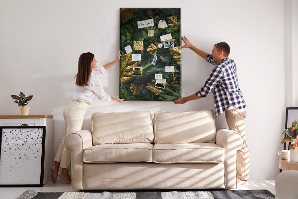 Memobord van kurk met gouden bladeren in een tropische plantencompositie
