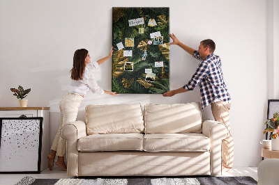 Memobord van kurk met gouden bladeren in een tropische plantencompositie