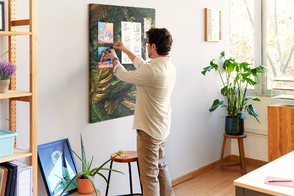 Memobord van kurk met gouden bladeren in een tropische plantencompositie