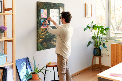 Memobord van kurk met gouden bladeren in een tropische plantencompositie