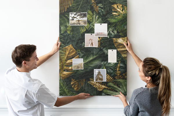 Memobord van kurk met gouden bladeren in een tropische plantencompositie