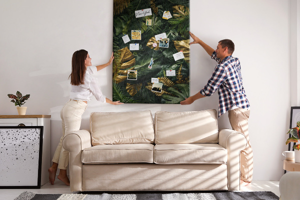 Memobord van kurk met gouden bladeren in een tropische plantencompositie