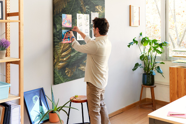 Memobord van kurk met gouden bladeren in een tropische plantencompositie