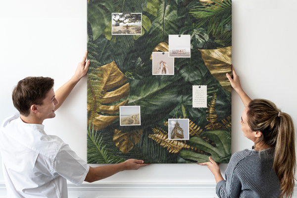 Memobord van kurk met gouden bladeren in een tropische plantencompositie