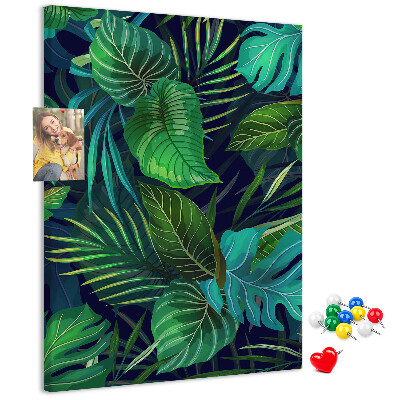Memobord van kurk met tropische bladeren op een donkere achtergrond
