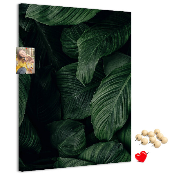Kurken prikbord met print van groene bladeren op een donkere achtergrond