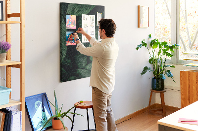 Kurken prikbord met print van groene bladeren op een donkere achtergrond