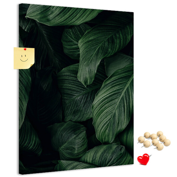 Kurken prikbord met print van groene bladeren op een donkere achtergrond