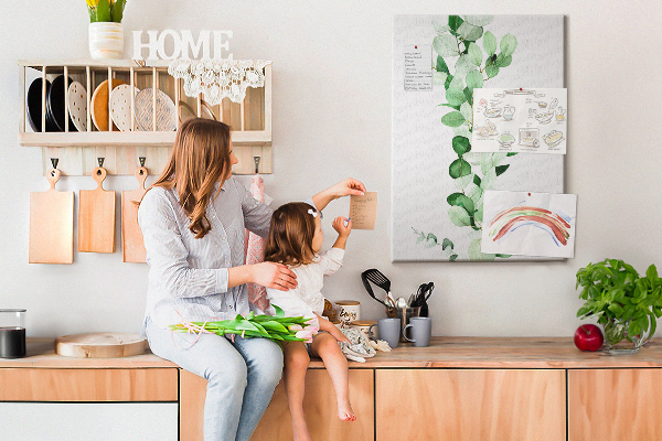 Kurken memobord met groene bladeren op een lichte achtergrond