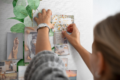 Kurken memobord met groene bladeren op een lichte achtergrond