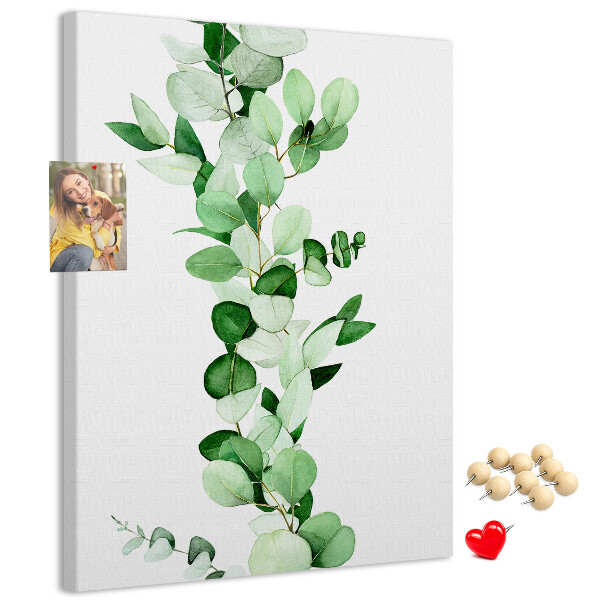 Kurken memobord met groene bladeren op een lichte achtergrond