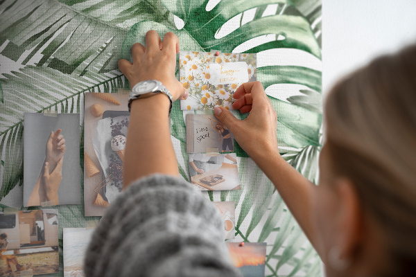 Kurken memobord met tropische bladeren in verschillende tinten groen