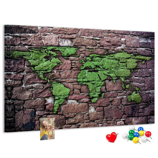 Prikbord met een wereldkaart in groentinten op een stenen muur