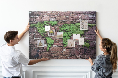 Prikbord met een wereldkaart in groentinten op een stenen muur