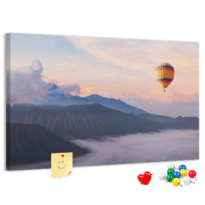 Prikbord met een ballon tegen een berglandschap bij zonsopgang