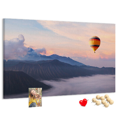 Prikbord met een ballon tegen een berglandschap bij zonsopgang