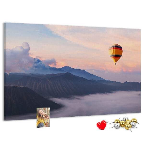 Prikbord met een ballon tegen een berglandschap bij zonsopgang