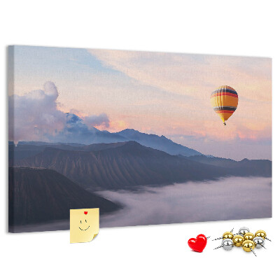 Prikbord met een ballon tegen een berglandschap bij zonsopgang