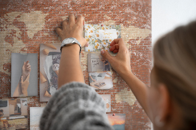 Kurkbord wereldkaart tegen een bakstenen muur