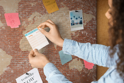 Kurkbord wereldkaart tegen een bakstenen muur