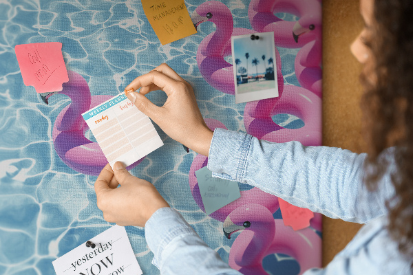 Prikbord met afbeelding van roze flamingo's tegen blauw water
