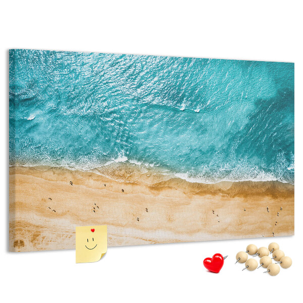 Kurkbord met een afbeelding van een strand met golven en voetsporen
