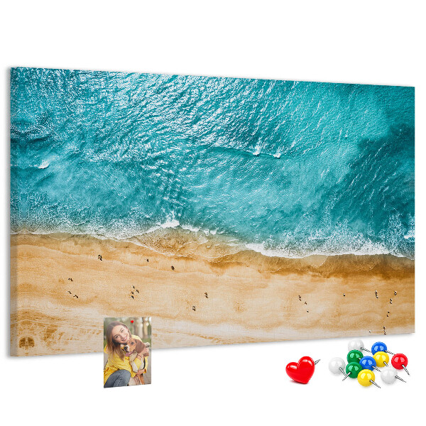 Kurkbord met een afbeelding van een strand met golven en voetsporen