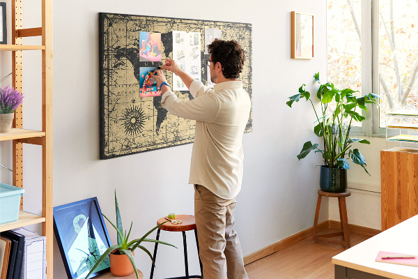 Prikbord met een oude wereldkaart in zwart en goud