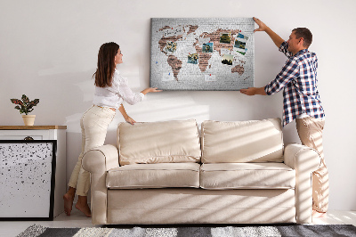 Kurkbord wereldkaart met een achtergrond van een bakstenen muur