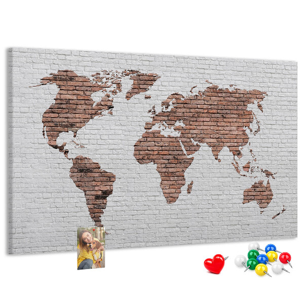 Kurkbord wereldkaart met een achtergrond van een bakstenen muur