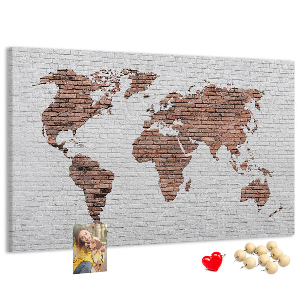 Kurkbord wereldkaart met een achtergrond van een bakstenen muur