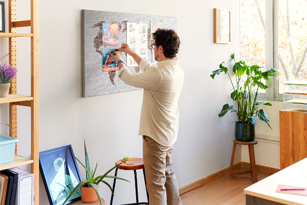 Kurkbord wereldkaart met een achtergrond van een bakstenen muur
