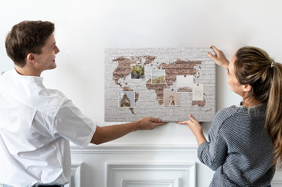 Kurkbord wereldkaart met een achtergrond van een bakstenen muur
