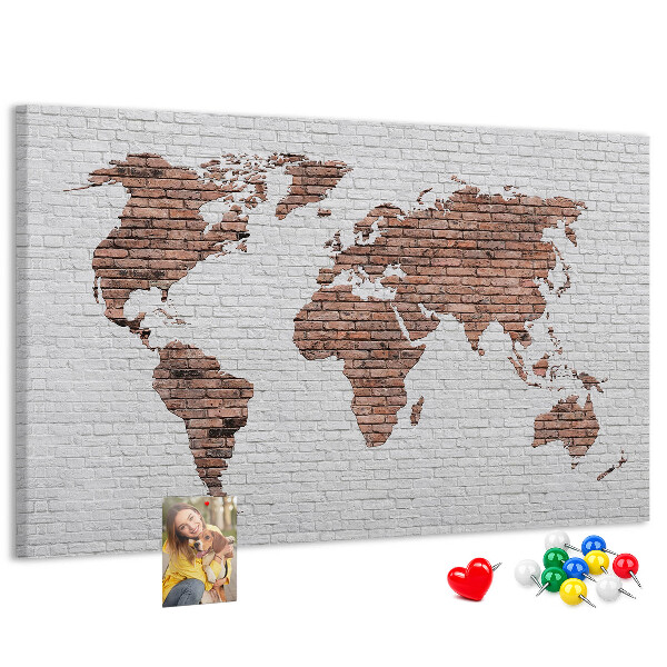 Kurkbord wereldkaart met een achtergrond van een bakstenen muur