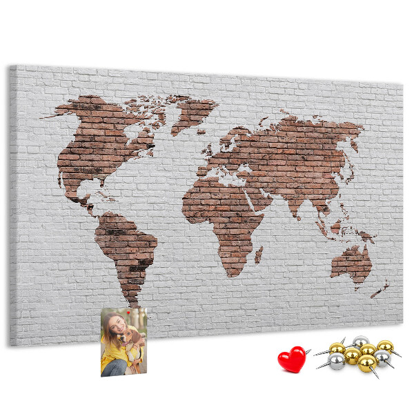 Kurkbord wereldkaart met een achtergrond van een bakstenen muur