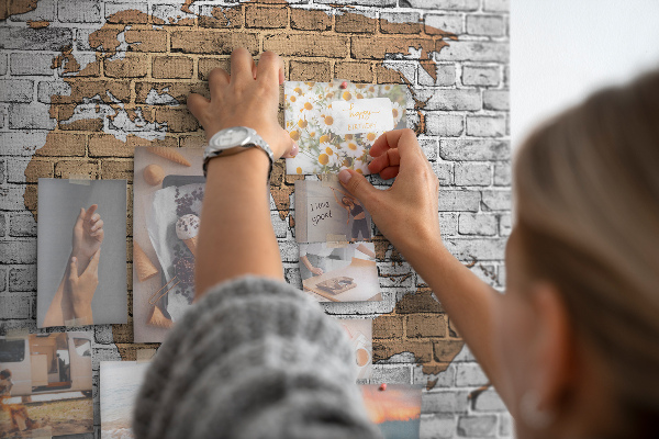 Kurkbord wereldkaart op een bakstenen muur