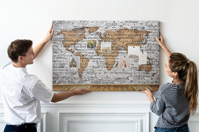 Kurkbord wereldkaart op een bakstenen muur