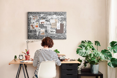 Kurken prikbord wereldkaart op een bakstenen muur