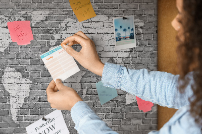 Kurken prikbord wereldkaart op een bakstenen muur