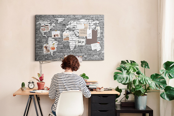 Kurken prikbord wereldkaart op een bakstenen muur
