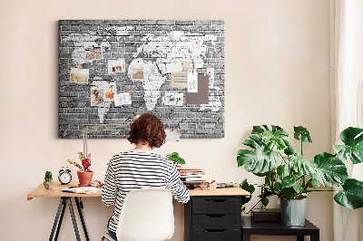 Kurken prikbord wereldkaart op een bakstenen muur
