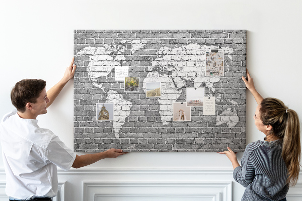 Kurken prikbord wereldkaart op een bakstenen muur
