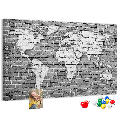 Kurken prikbord wereldkaart op een bakstenen muur