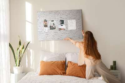Kurk prikbord met afbeelding van witte bakstenen muur met kleurrijke punaises