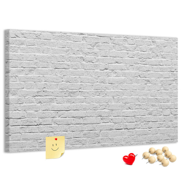Kurk prikbord met afbeelding van witte bakstenen muur met kleurrijke punaises