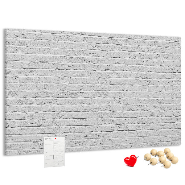 Kurk prikbord met afbeelding van witte bakstenen muur met kleurrijke punaises