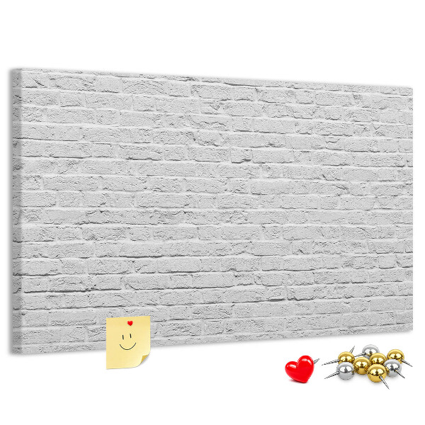 Kurk prikbord met afbeelding van witte bakstenen muur met kleurrijke punaises