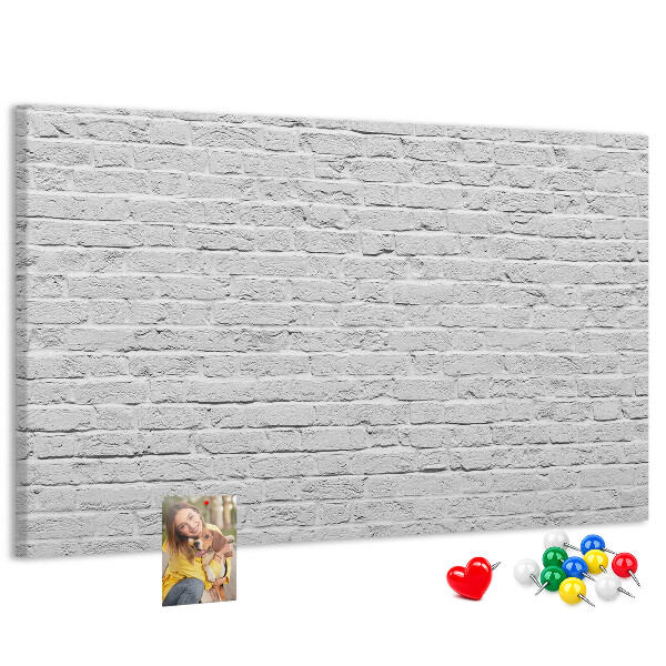 Kurk prikbord met afbeelding van witte bakstenen muur met kleurrijke punaises